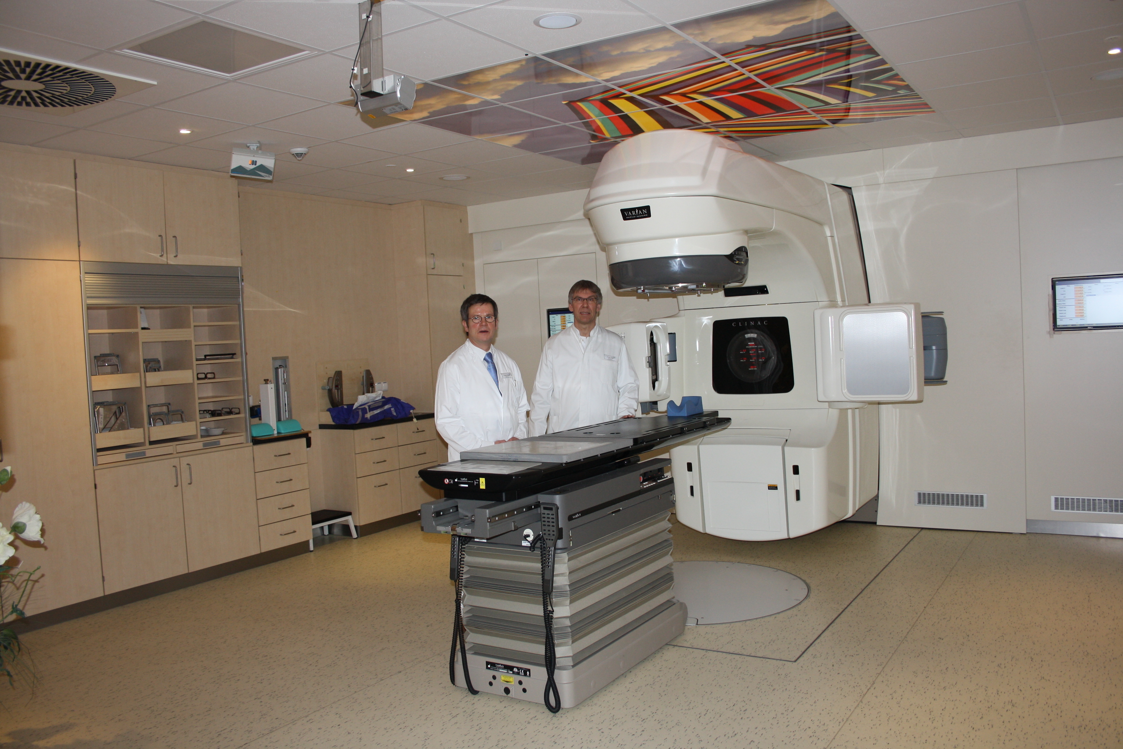C323838Linearbeschleuniger_Krankenhaus_Buchholz_4_13a.JPG Großzügige Räumlichkeiten und neueste Technik für Schmerzpatienten: Dr. Peter Andreas und Dr. Uwe Imgart (v.li.) vor einem Linearbeschleuniger in der Strahlentherapie im Krankenhaus Buchholz