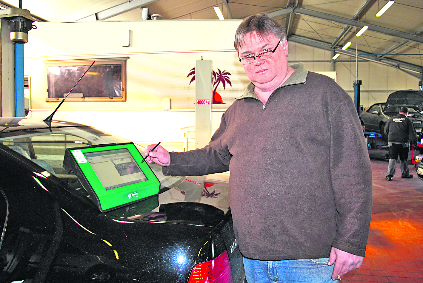 Uwe Braun am Diagnosegerät, das dem Auto "vermitteln" muss, dass es eine neue Batterie bekommen hat