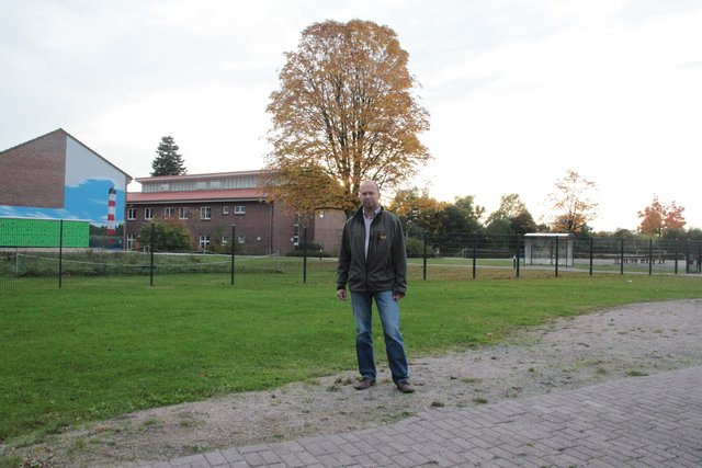 Bürgermeister Sönke Hartlef auf dem Schul-Vorplatz Dort entstehen Pkw-Stellplätze für Eltern der Schulkinder