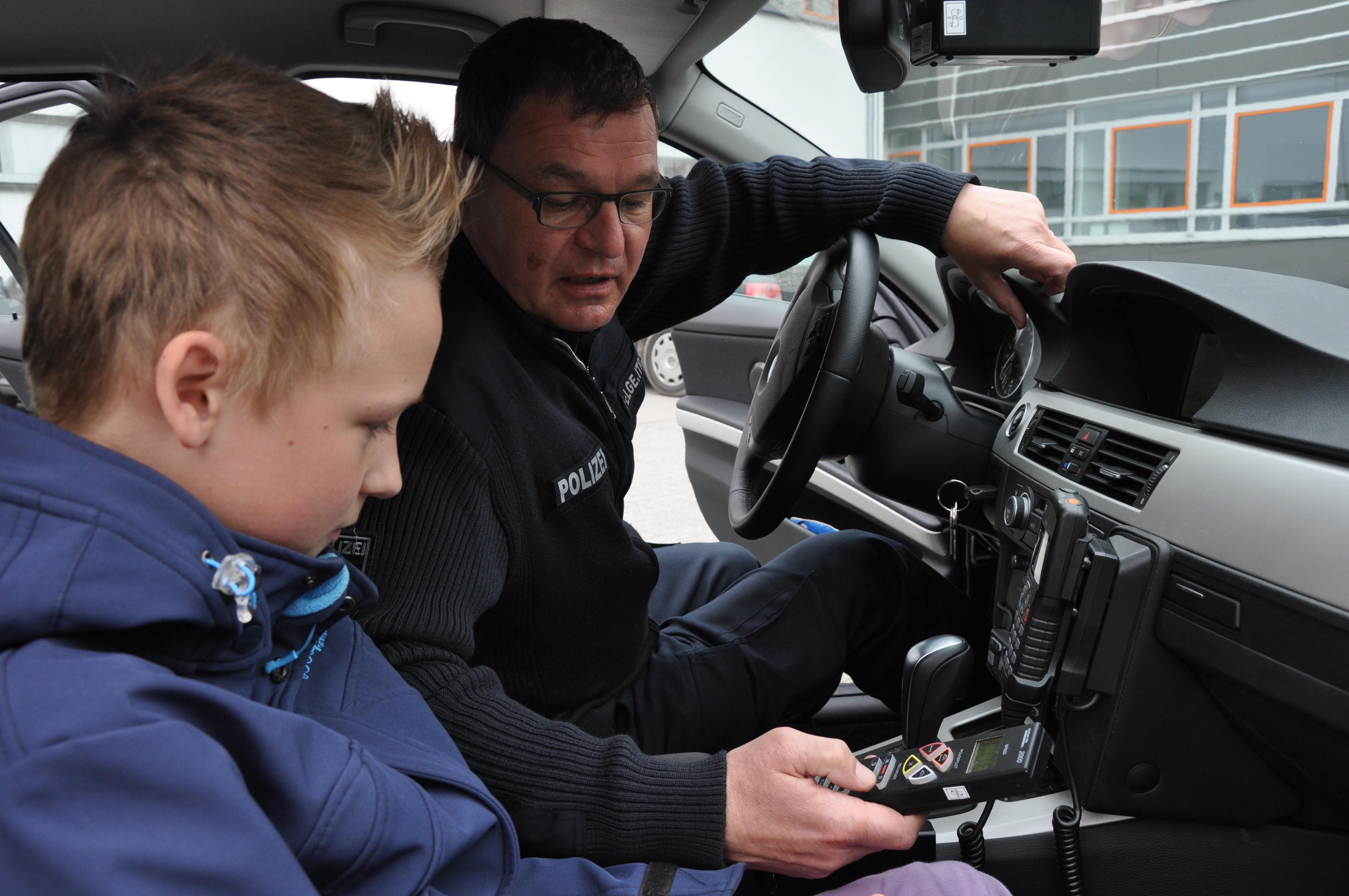 Lukas lässt sich von Polizeioberkommissar Felgentreu die Bedienung der Videomessanlage erklären