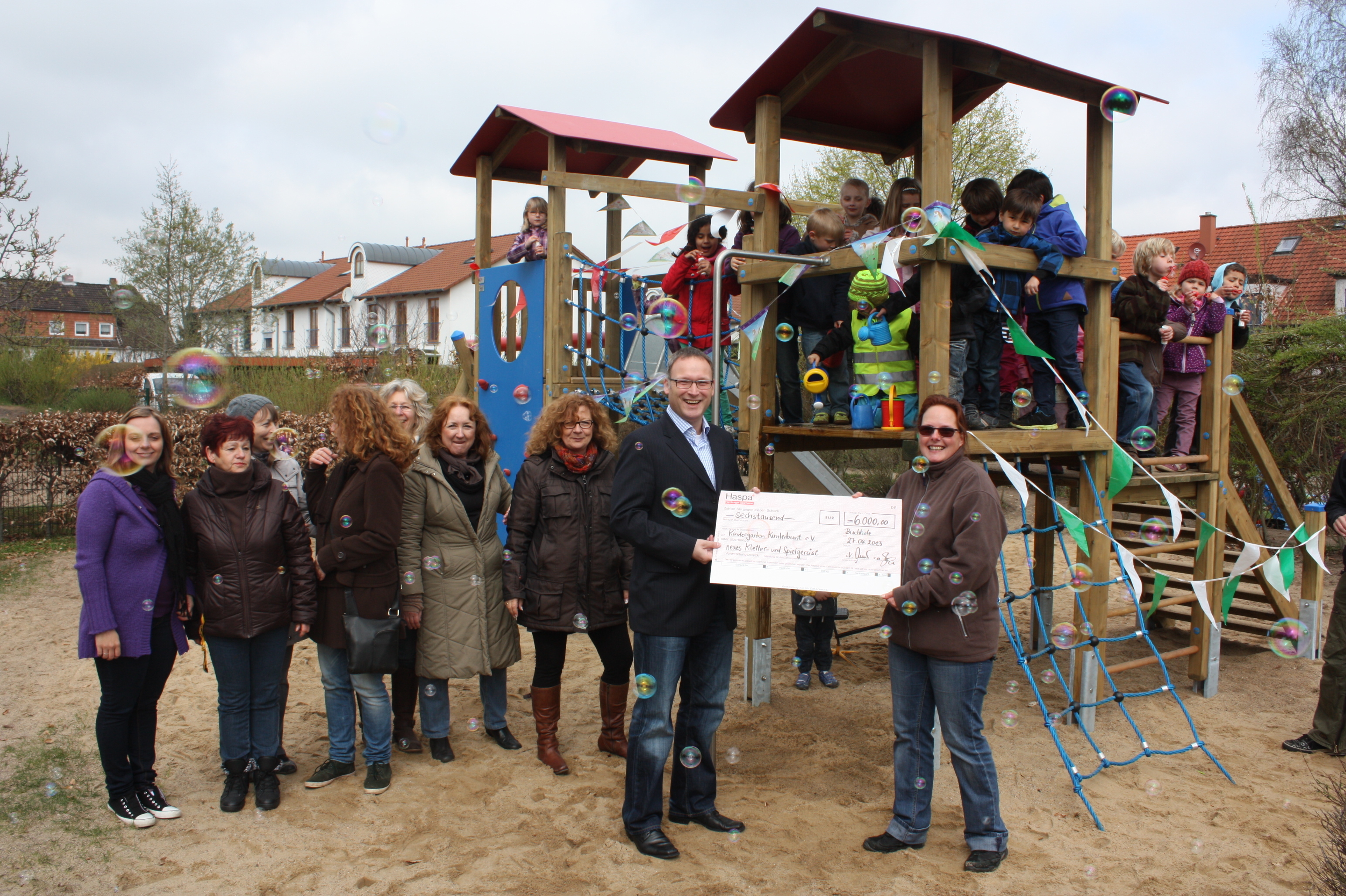 Mitten in den Seifenblasen übergab Andree Müller von das Haspa den Scheck über 6.000 Euro an die Vertreter des Kindergartens Kunterbunt