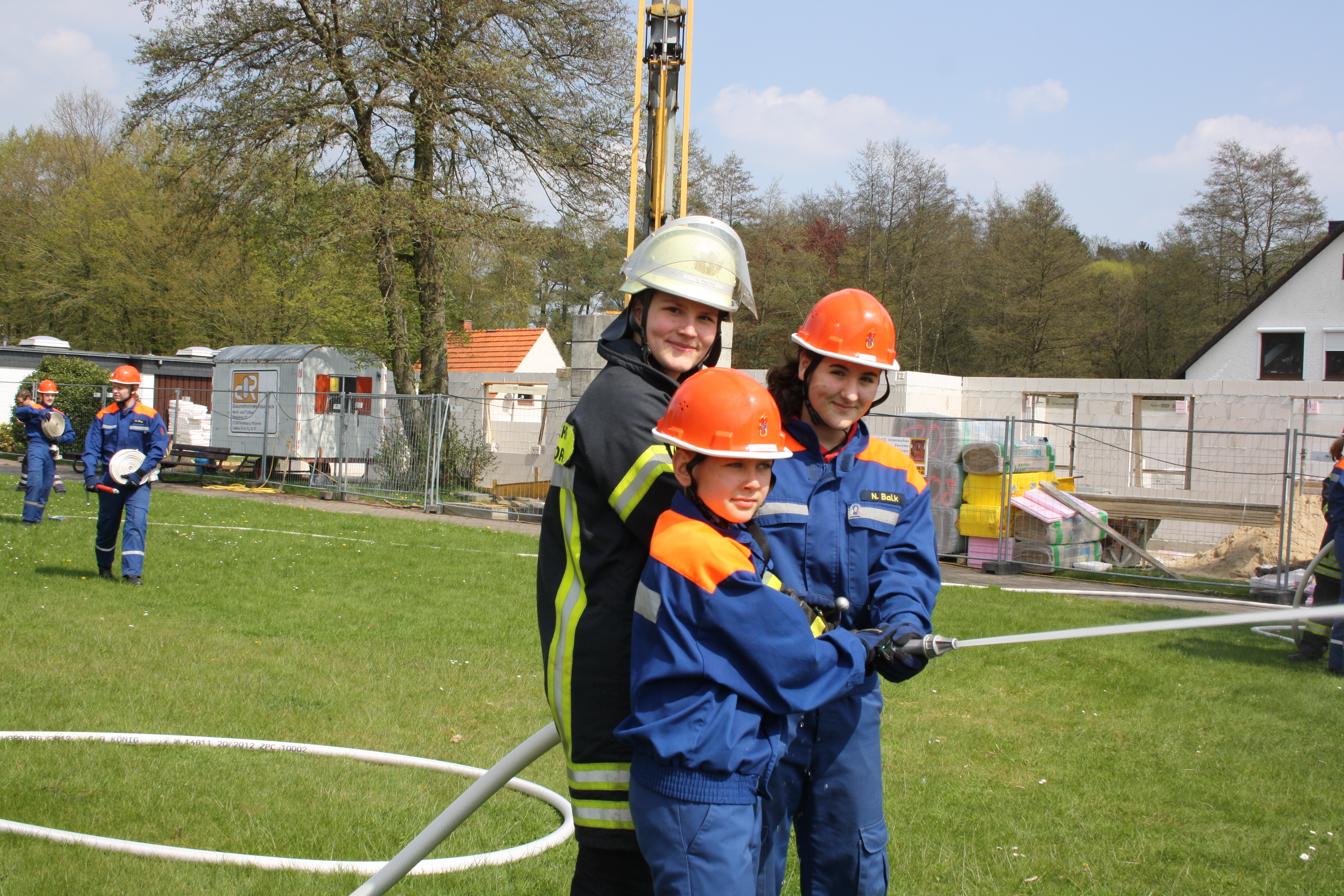 Jugendbetreuerin Claudia mit den beiden Nachwuchsfeuerwehrleuten Paul und Nadine bei der Demonstration eines Löschangirffs