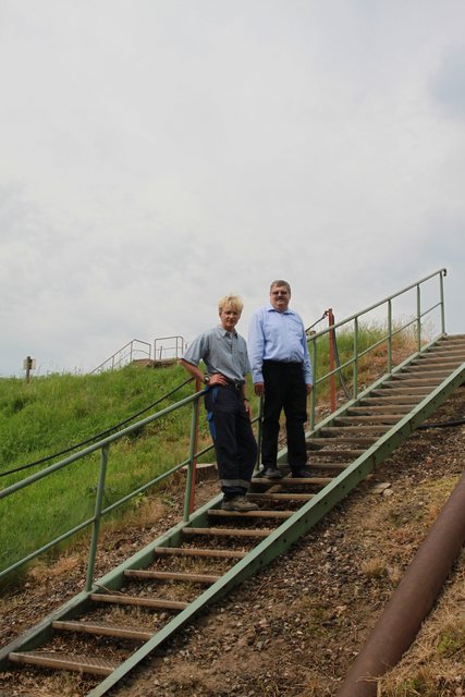 Eine Treppe führt auf den Deich der Rotschlamm-Halde: AOS-Geschäftsführer Eberhard Guhl (re.) und Deponie-Betriebsleiter Oliver Guttau