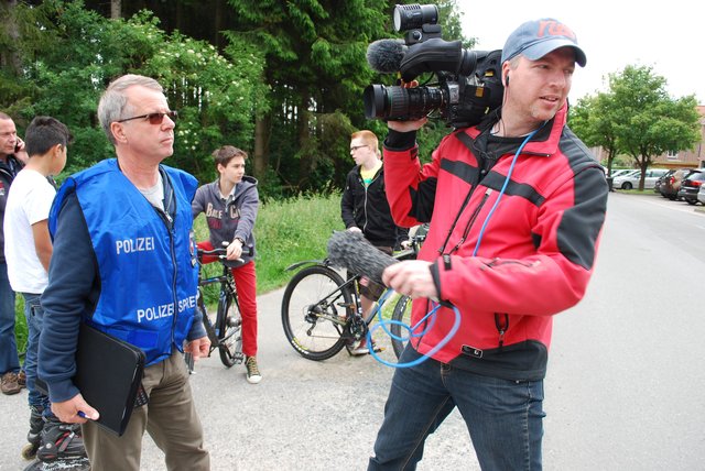 Polizeisprecher Michael Düker (li.) steht Medienvertretern vor Ort Rede und Antwort