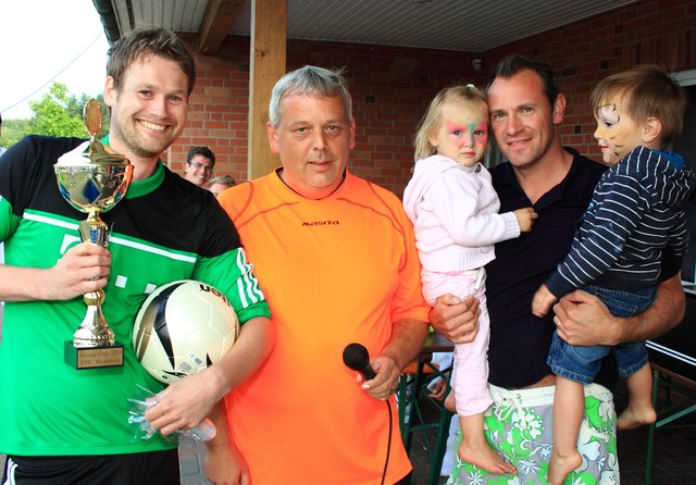 Pokalübergabe (v.l.): Der Estetaler Käpten Hauke Tensfeldt, TSV-Obmann Jürgen Tödter und Sponsor Henrik Lohmann (Allianz) mit seinen Kindern Finja und Keno