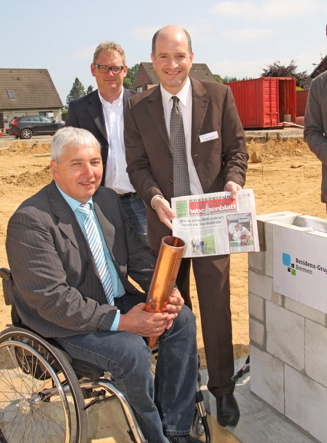 Ahlerstedts Bürgermeister Uwe Arndt sowie Dirk Brand und Carsten Adenäuer (v.li.) von der Residenz-Gruppe mit dem WOCHENBLATT und der "Zeitkapsel"
