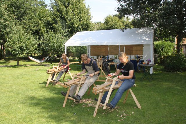 Die jungen Männer und Frauen fertigen Holznägel
