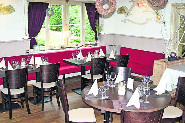 Ein Gastraum in kräftigen Rot- und Brauntönen. Hier genießt man seinen Aufenthalt