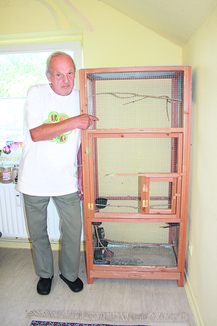 Rolf Pöker steht vor einem Flugkäfig. Am meisten fehlen im seine Kanarienvögel