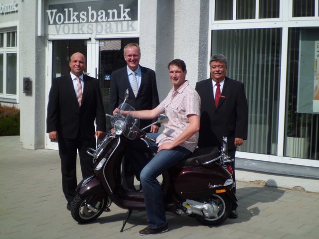 Björn Großmann (v. li.) und Dietmar Bruß sowie Hans-Georg Keuchen (re.) überreichen Stephan Knack seinen Roller | Foto: Volksbank Kehdingen