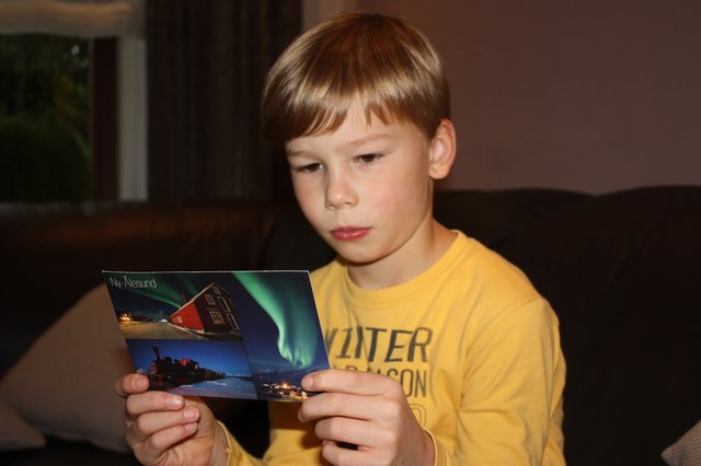 Finn Seide liest die Karte, die ihm Seemann Roman Boxler von der norwegischen Inselgruppe Spitzbergen schickte