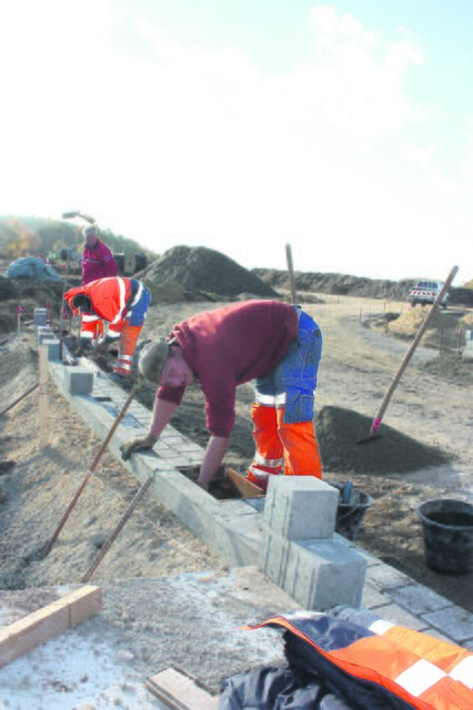 Bauarbeiter setzen die Randsteine am Kreisel