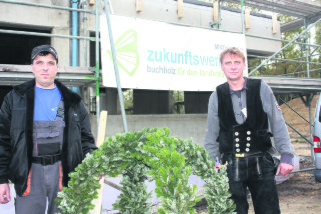 Die Handwerker Wladislaw Ruff (li.) und Jörg Skorzinski von der Firma Krogmann mit dem Richtkranz