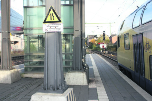 Das Schild besagt, dass die Durchfahrt für Rollstuhlfahrer zum Fahrstuhl zu eng ist. Eine Alternative wird nicht benannt