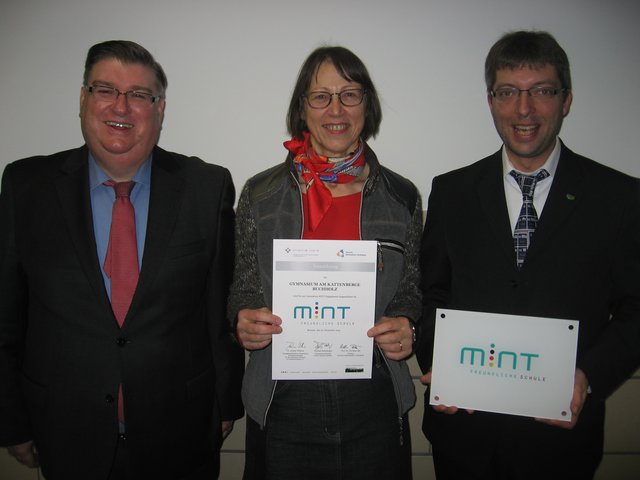 Mit dem "MINT-Siegel" (v. li.): Schulleiter Armin May, MINT-Beauftragte Brigitte Muntermann und André Gand (Fachbereich Chemie)