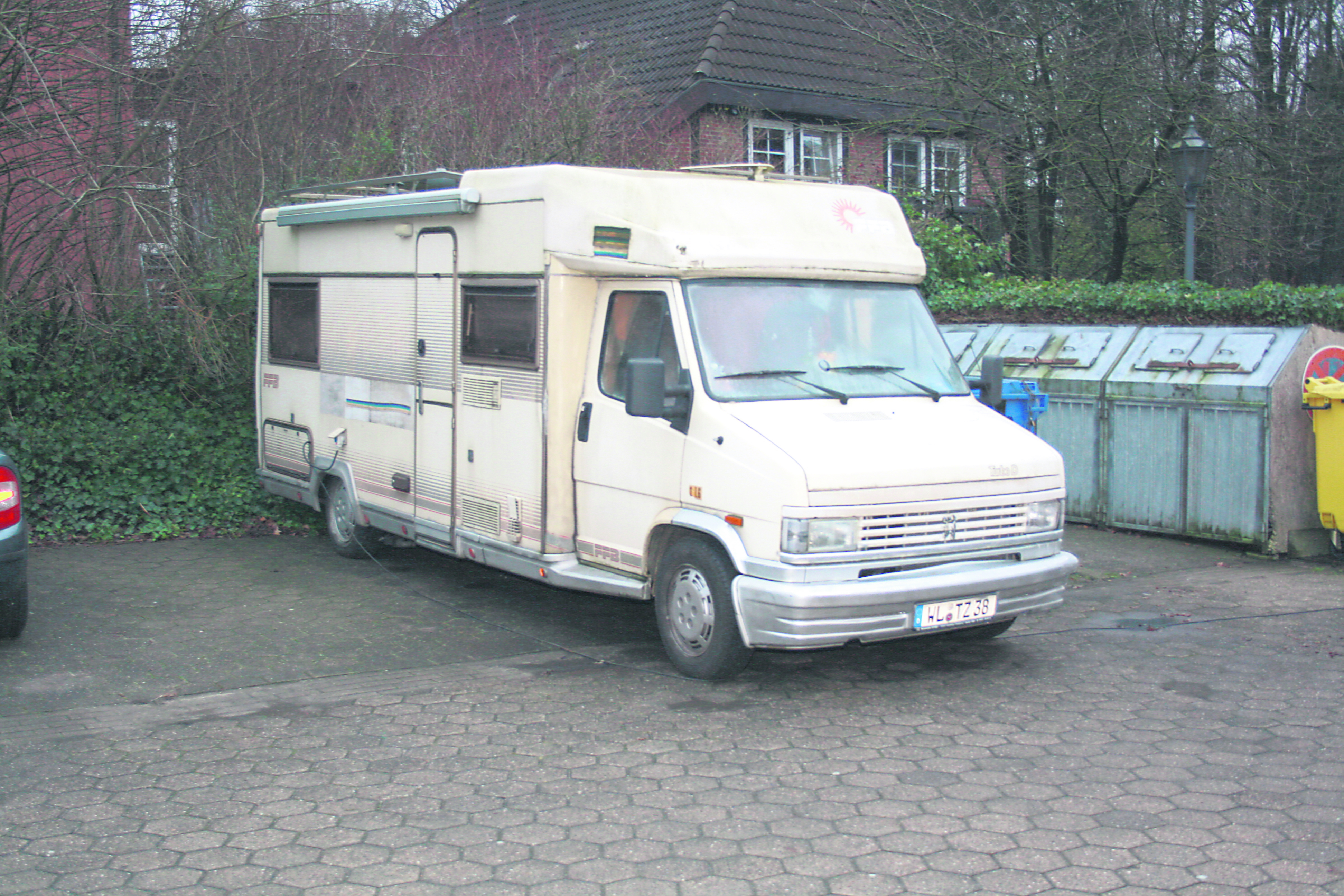 Das Wohnmobil steht oft mit laufendem Motor auf einem Parkplatz in Jesteburg. Im Hintergrund das Seniorenheim