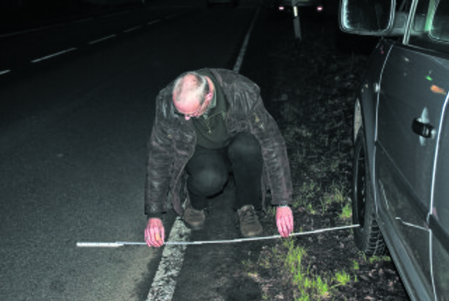 Der Wagen muss korrekt stehen. Deshalb misst Norbert Ewald den Abstand der Räder zum Straßenrand