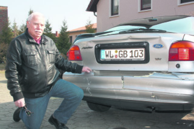 Gerhard Bergenroth zeigt auf sein ramponiertes Auto