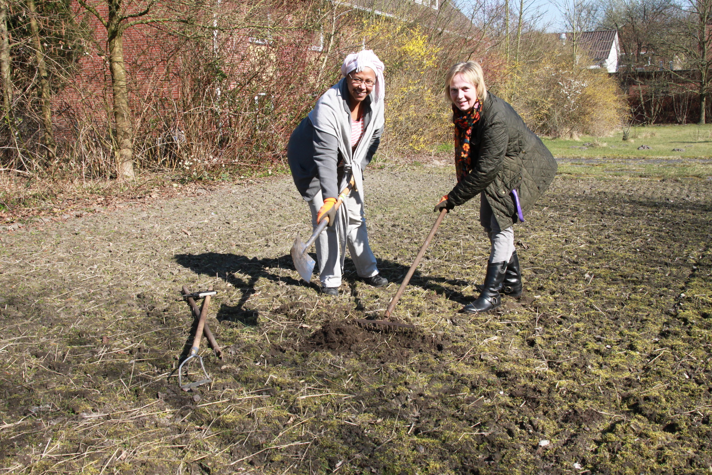 Erster Spatenstich im internationalen Garten: Iyamide Mahdi (li.) und Heide von Limburg