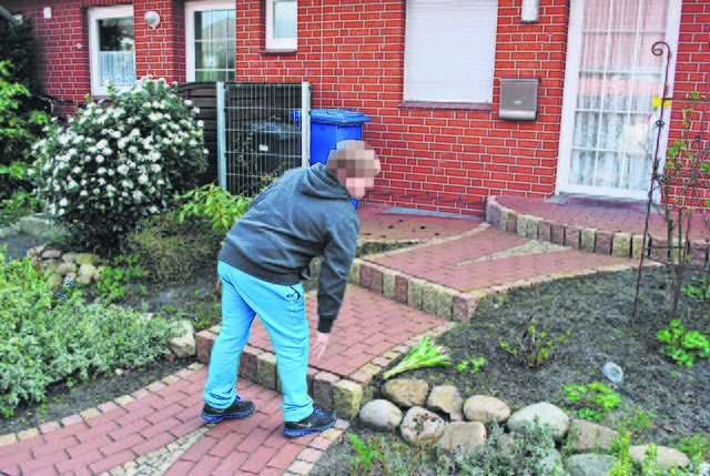 Ein Junge, der das getötete Mädchen kannte, legt Blumen vor dem Reihenhaus der Familie ab