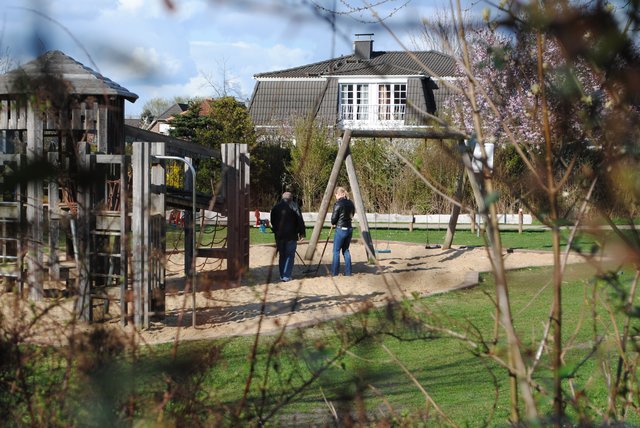 Polizisten suchen einen Spielplatz mit Metalldetektoren ab