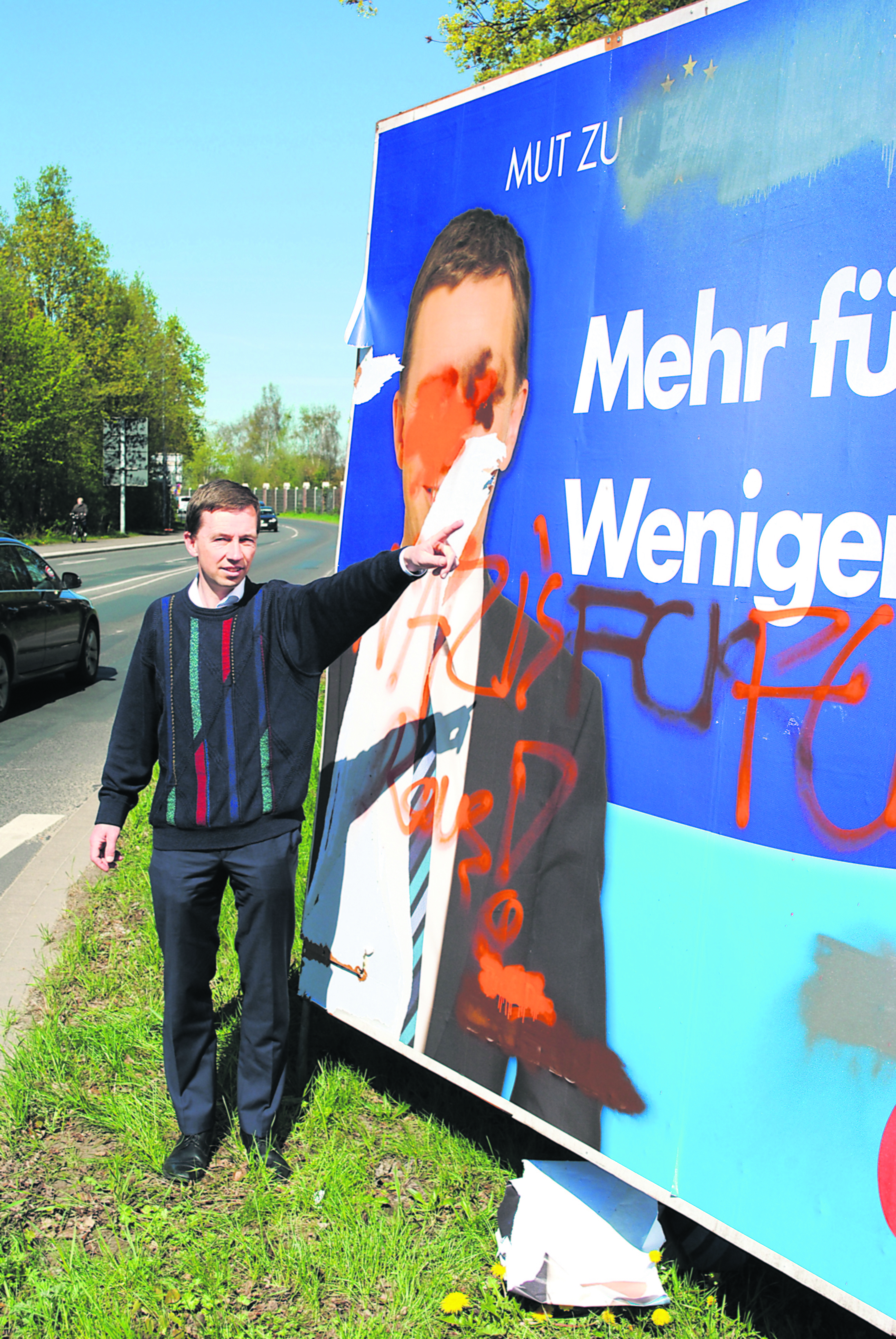 AfD-Chef Bernd Lucke zeigt eine beschmierte Plakat-Stellwand in Winsen