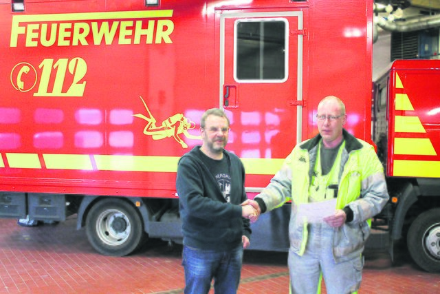 Bernd Hauke (li.), Leiter der Tauchergruppe "Florian", bedankt sich bei Jürgen Peters für die Spende