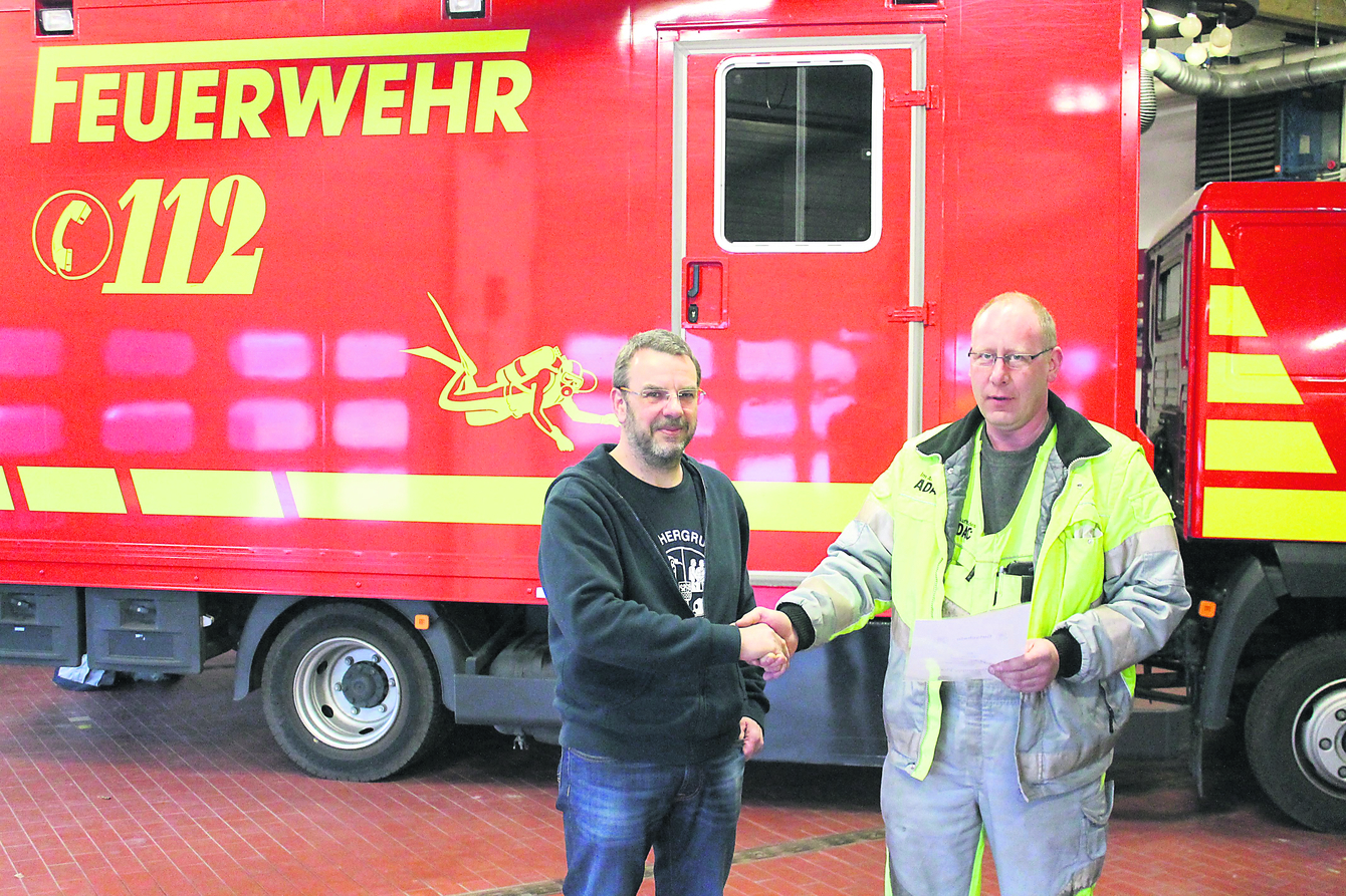 Bernd Hauke (li.), Leiter der Tauchergruppe "Florian", bedankt sich bei Jürgen Peters für die Spende