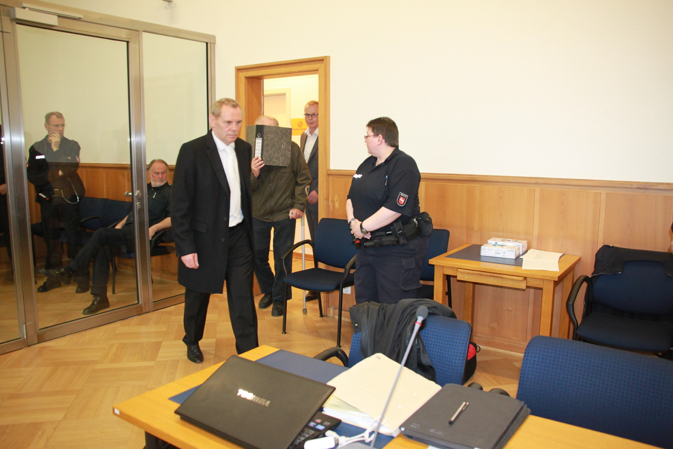 Szene vom Prozess-Auftakt: Der Angeklagte betritt mit seinen beiden Anwälten der Gerichtssaal
