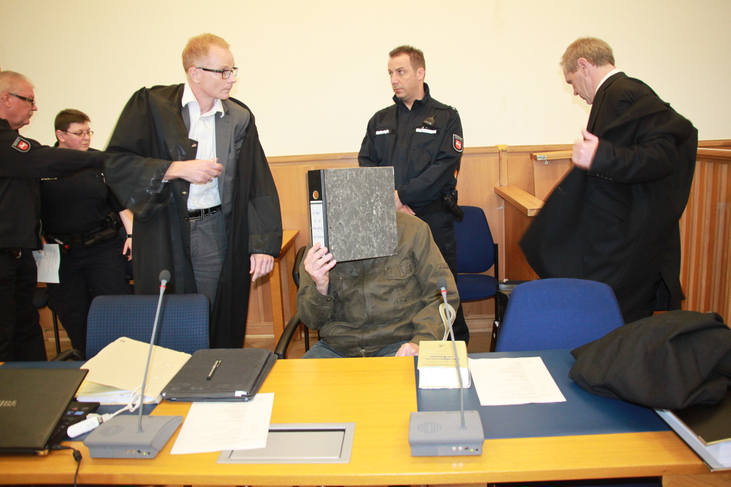 Beim Prozessauftakt Ende April: der Angeklagte (Mi.), seine Anwälte und Justizbedienstete
