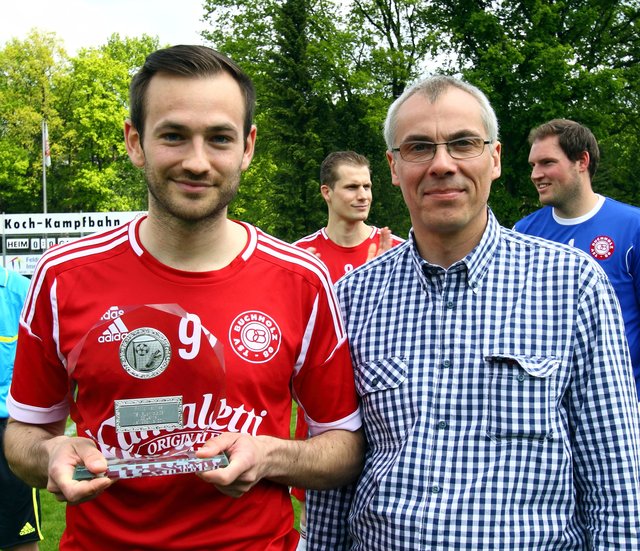 Liga-Manager Simon Beecken (re.) überreichte Philip Mathies eine Glasplakette zur Erinnerung an 25 Jahre Fußball bei Buchholz 08