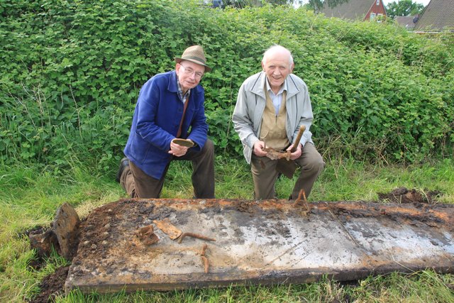 Zeitzeugen und Heimatforscher: Heinz Hauschild (li.) und Horst Hoferichter mit dem Fundstück, einem Trümmerteil eines Panzers "Sherman" aus dem Zweiten Weltkrieg