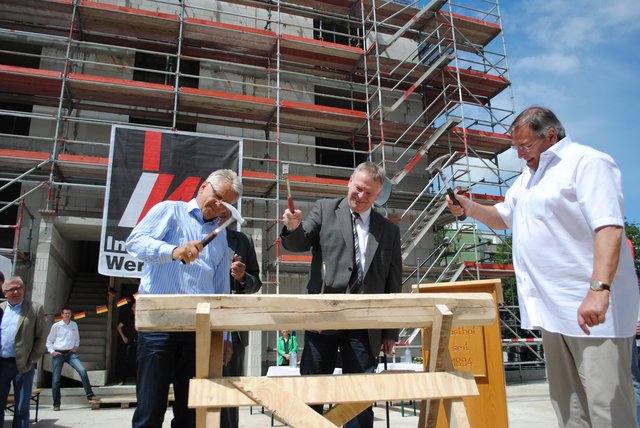 Peter Kuttner (Industriebau Wernigerode, v.li.), Frank Tipke von der Volksbank Stade-Cuxhaven und Peter Herlitschke, Geschäftsführer der "Hansa Wohn- und Gewerbebau", hämmern die obligatorischen letzten Nägel ein