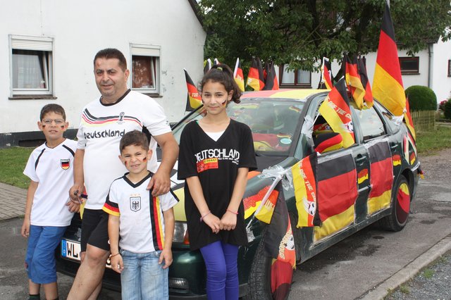 Bedingungslose Deutschland-Fans: (v. li.) Hassan, Ahmad, Mohamed und Shaima Faour vor dem geschmückten VW Polo