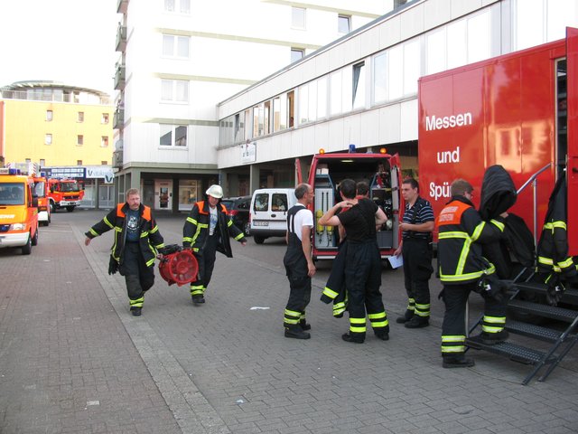 Feuerwehrleute (li.) bringen eine Lüftungsanlage zum Laden
