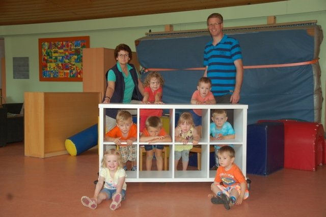 Ilsemarie Schliecker, Leiterin des Kindergartens Rappelkiste, Björn Schmahl, Inhaber vom Holzatelier, sowie einige der Kindergarten-Kinder mit dem neuen Spielzeugregal | Foto: Holzatelier / Rapelkiste