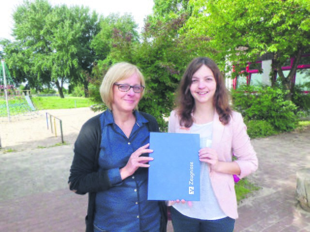 Antje Albrecht, Jugendmarkt-Mitarbeiterin bei der Volksbank Kehdingen, und Kerstin Völckers, Schulleiterin der Grundschule Drochtersen, bei der Mappenübergabe