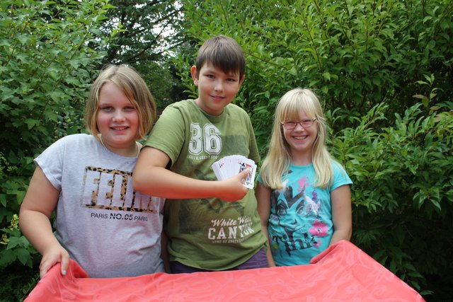 Julia (10) aus Beckdorf, Carsten (10) aus Beckdorf, und Lea (8) aus Revenahe bereiten einen Kartentrick vor