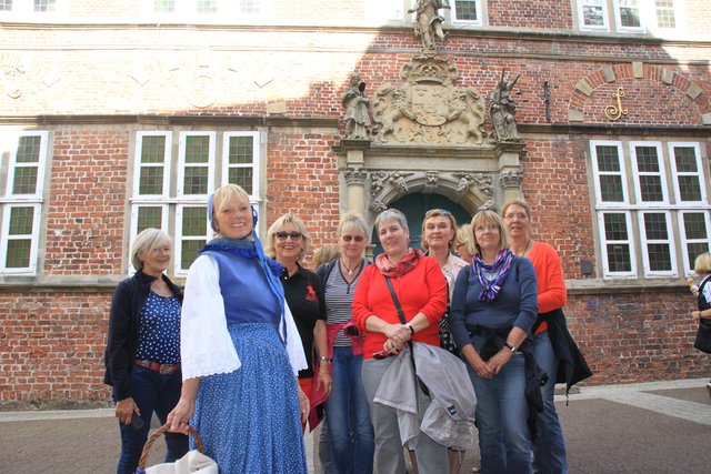 Der Damen-Kegelclub aus Münster bei der Altstadtbesichtigung mit Gästeführerin  Edith Bruns (2. v. li.) in Altländer Tracht
