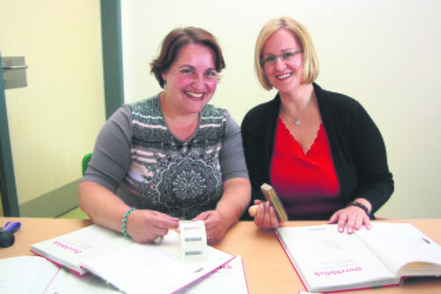 Schulleiterin Iris Strunk (li.) und ihre Stellvertreterin Nadine Ohmann stempeln die neuen Schulbücher