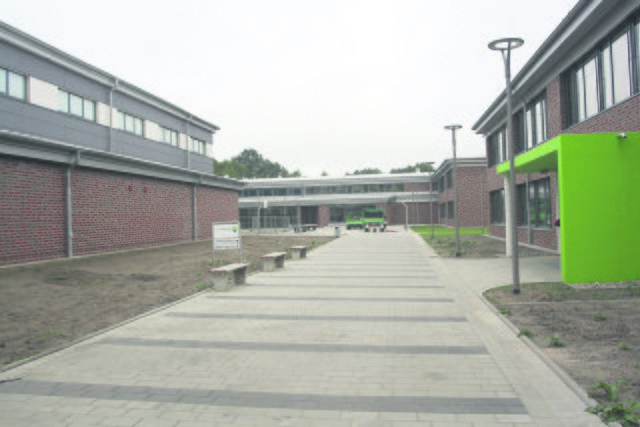 Ein Blick auf den Pausenhof: Sporthalle (li.), Hauptgebäude (Mitte) und Jahrgangshaus