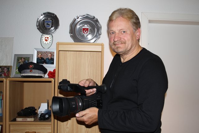Leidenschaftlicher Hobbyfilmer: Werner Schmidt mit seiner Kamera, im Hintergrund die Polizeimütze und -Abzeichen des pensionierten Polizisten