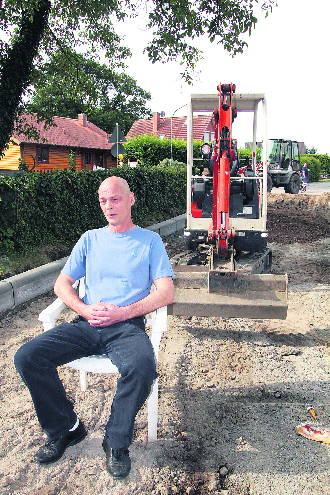 Passiver Widerstand mit dem Gartenstuhl: Manfred Balzer setzt sich gegen den anrückenden Bagger zur Wehr