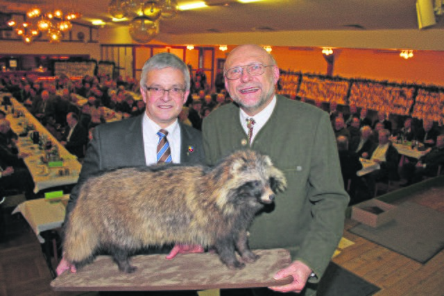 Landrat Michael Roesberg (li.) überreicht "Lernort Natur"-Organisator Peter Schneider ein neues Tierpräparat: einen Marderhund