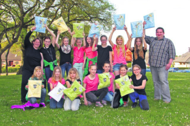 Schwenken ihre neuen Handtücher: die E-Juniorinnen des TuS Harsefeld mit ihren Betreuern Melanie Iden (li.) und Sven Kruse