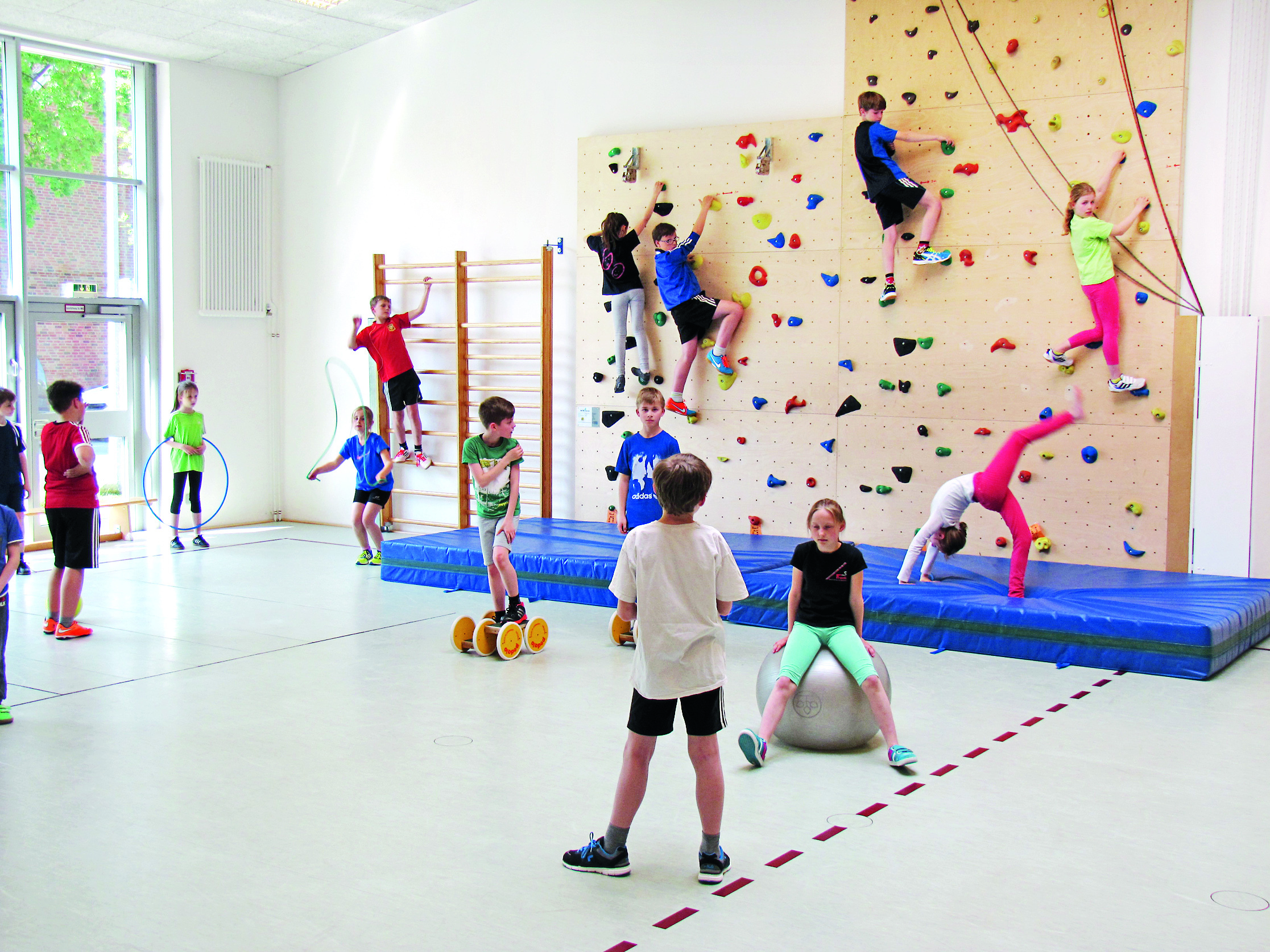 Spaß an körperlicher Betätigung: Schüler beim Ballspiel und an der Kletterwand