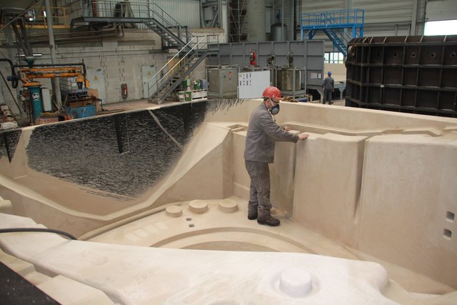 Handarbeit: Alex Naumann schlichtet mit Schleifpapier eine Sandform, in die später glühend heißes Eisen gegossen wird