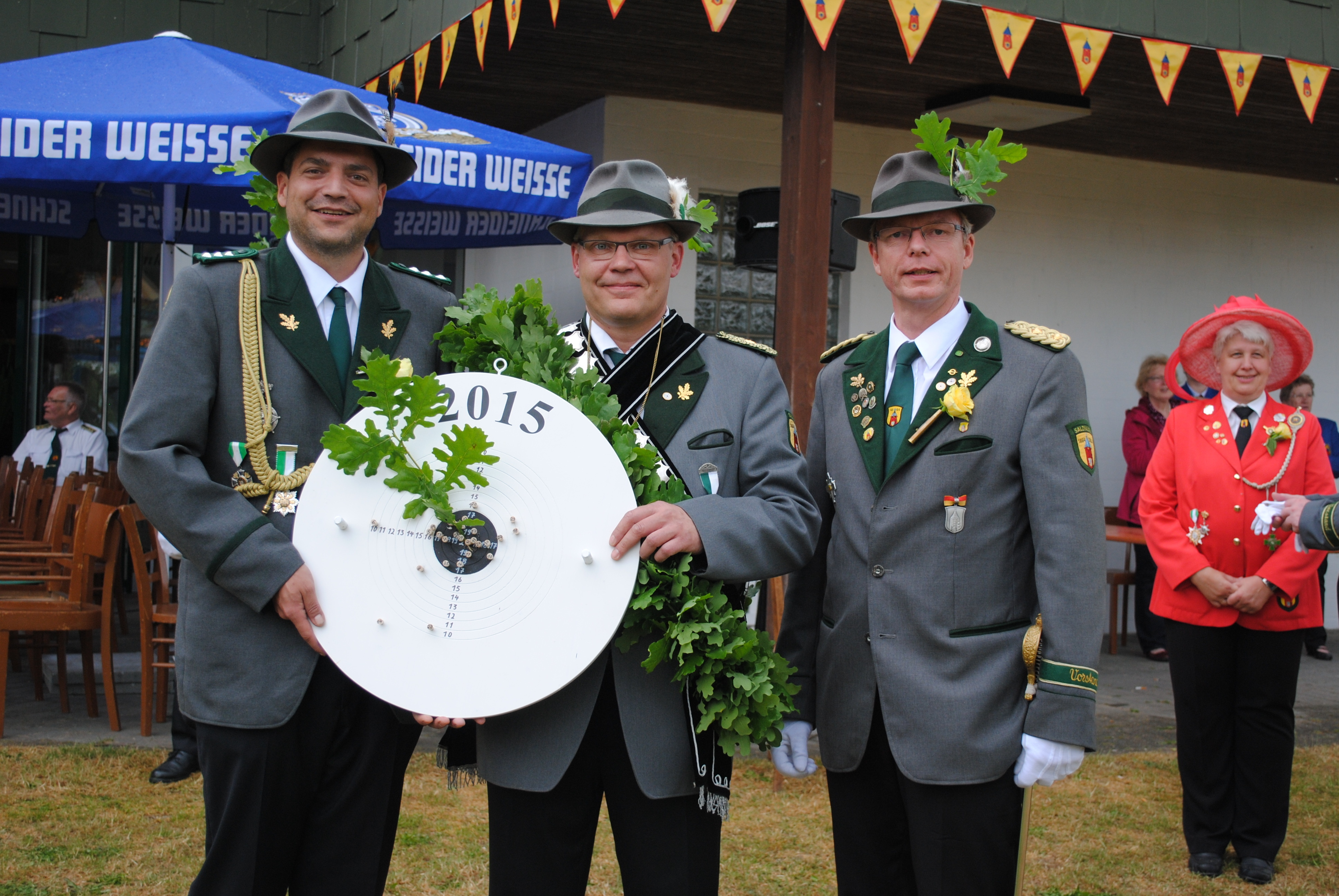 Bei der Proklamation (v. li.): Adjutant Alexander Jost, Schützenkönig Ralf Mädge und Oberst Dirk Hornbostel. Im Hintergrund Rosenkönigin Petra Putensen