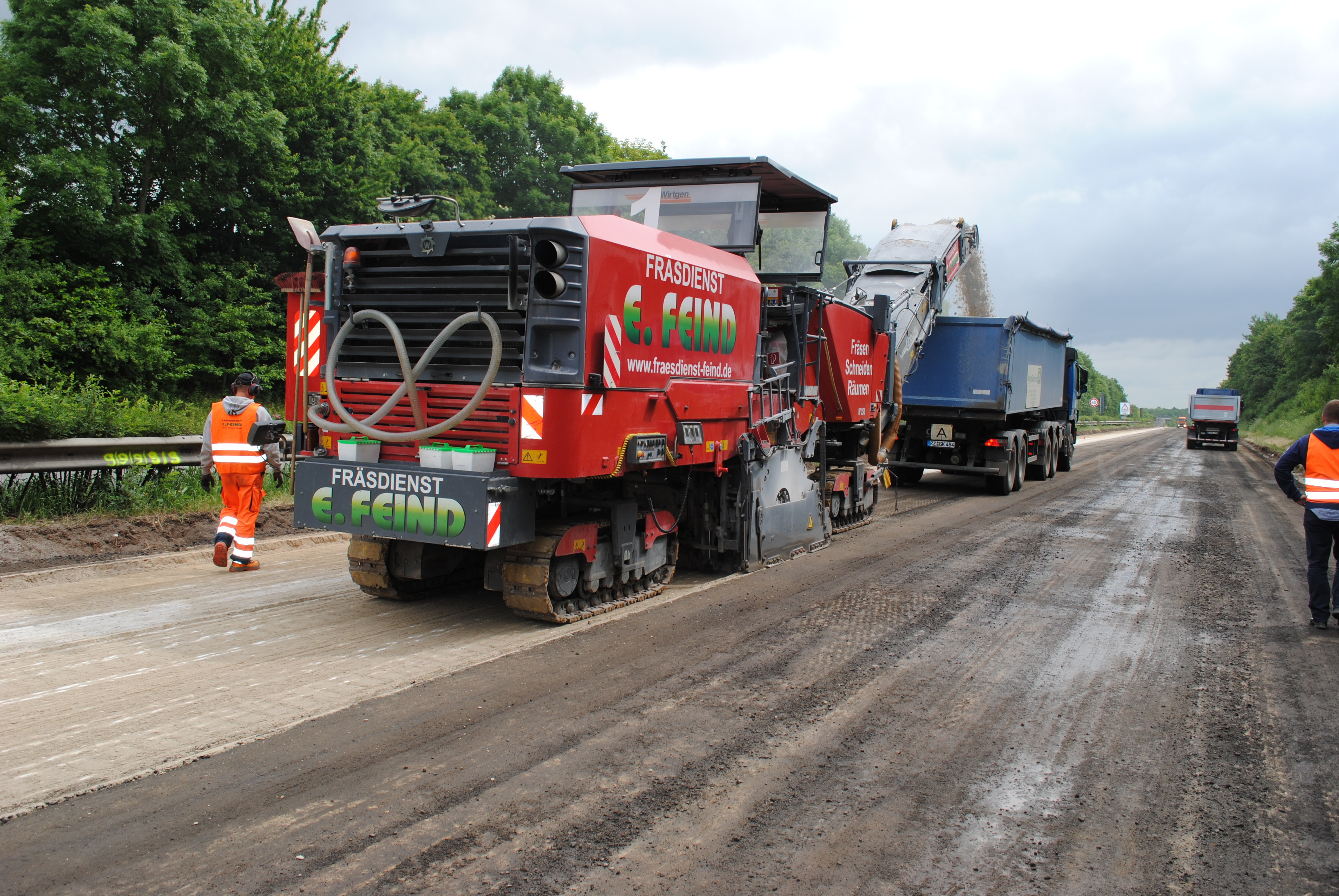 Langsam bahnt sich die Fräsmaschine ihren Weg und fördert den Baustoff gleich auf einen bereitstehenden Lkw