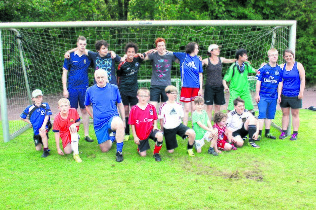 Eingeschworene Gemeinschaft: das integrative Fußballteam des Buchholzer FC mit Trainer Hartmut Stoldt (vorn, 3. v. li.)